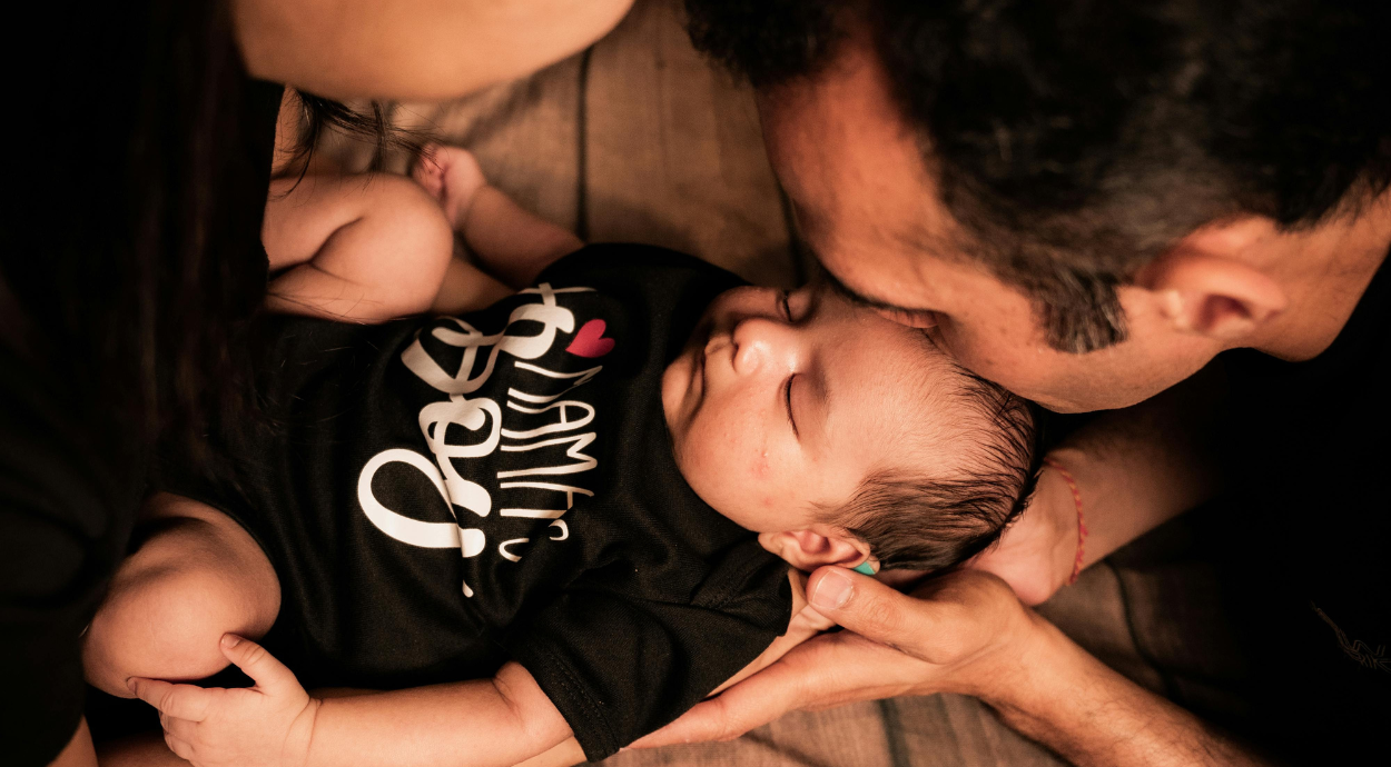 Parent holding their baby in hand