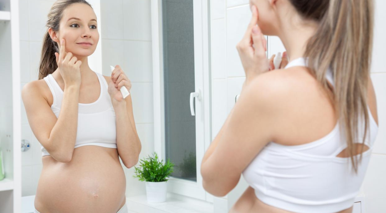 A pregnant woman doing skin care
