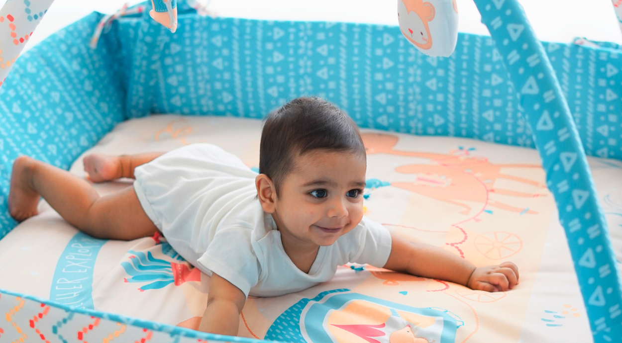 A baby is playing in a play gym