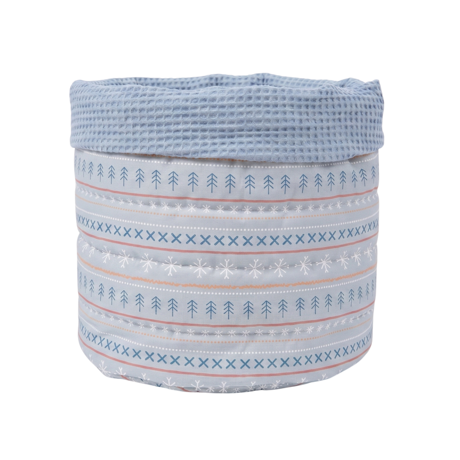 A round fabric storage basket with a waffle-weave top band in light blue, and a striped body featuring white, light blue, and pale pink patterns of pine trees, snowflakes, and X's on a white background.