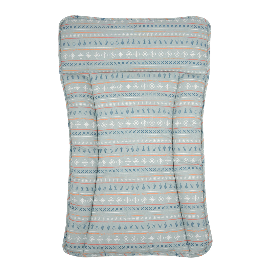 A rectangular padded baby changing station rounded corners, featuring a horizontal Nordic pattern of snowflakes, pine trees, and geometric stripes in light blue, white, and dusty pink on a white background.