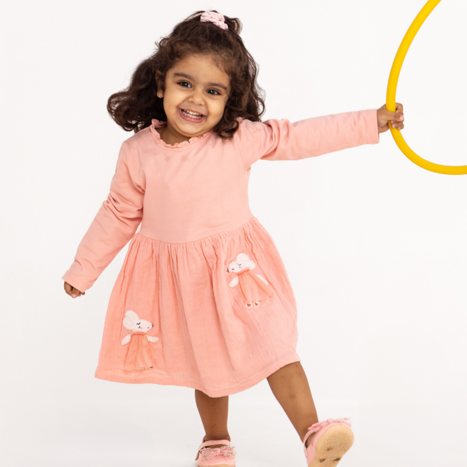 A baby girl wearing light orange color mouse frock dress