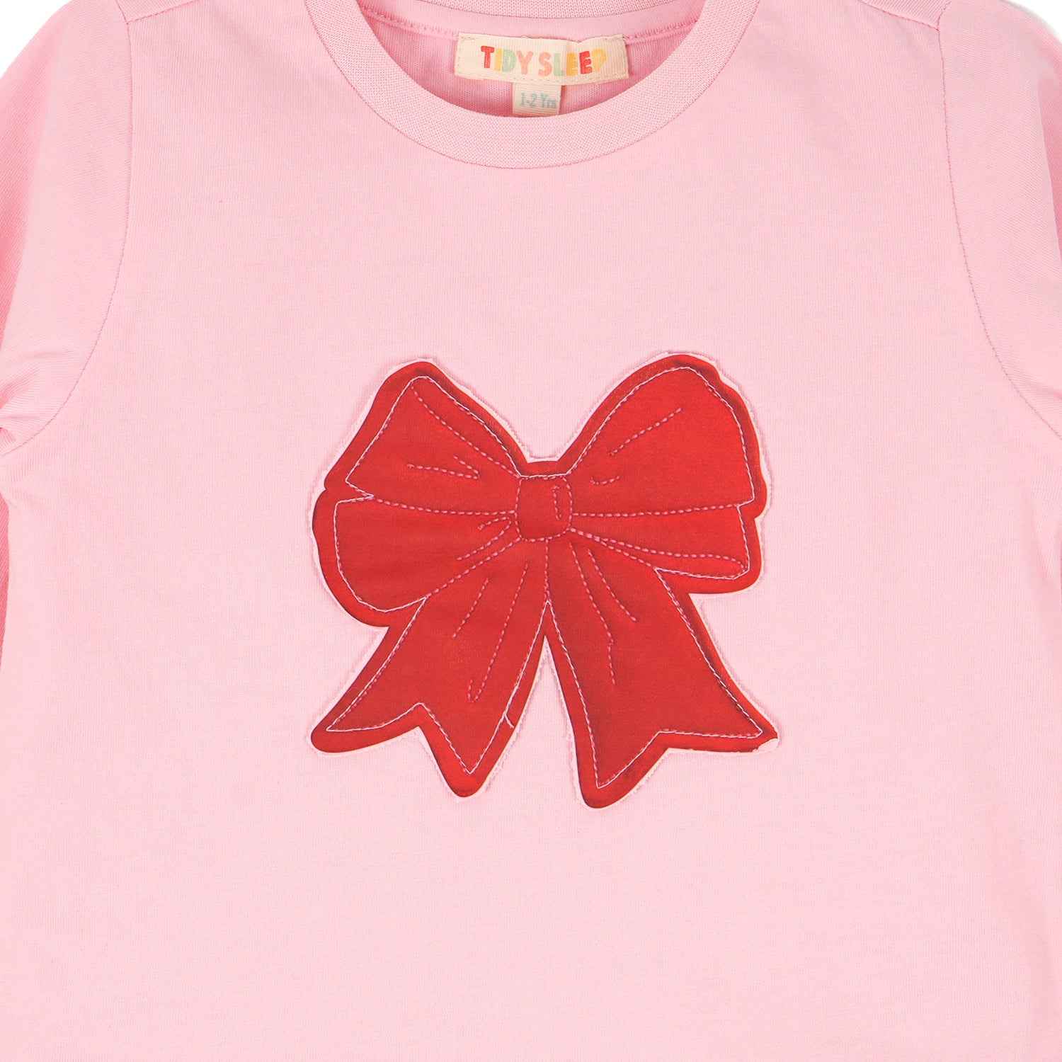 Closeup of a large red bow on the chest of Cotton Night Suit