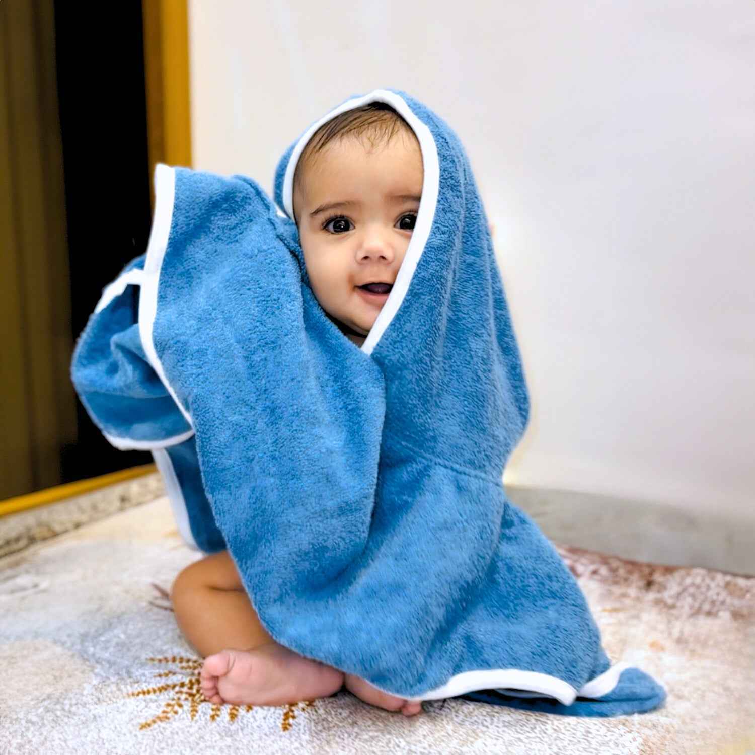 Baby wrapped in blue Poncho Towel