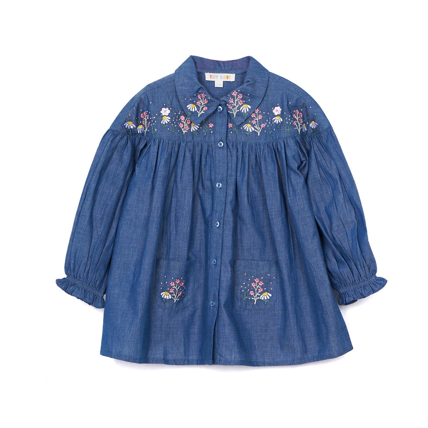 Blue denim baby shirt with floral embroidery on the collar and pockets, featuring a button-up design and long puffed sleeves.