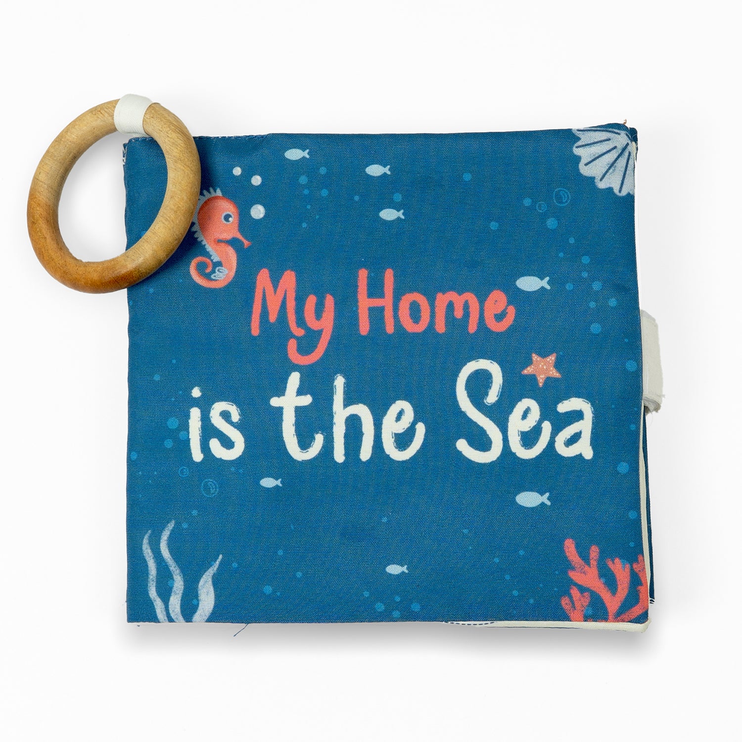 Front view of a folded fabric book with a blue cover featuring the text "My Home is the Sea" and colorful sea-themed illustrations.