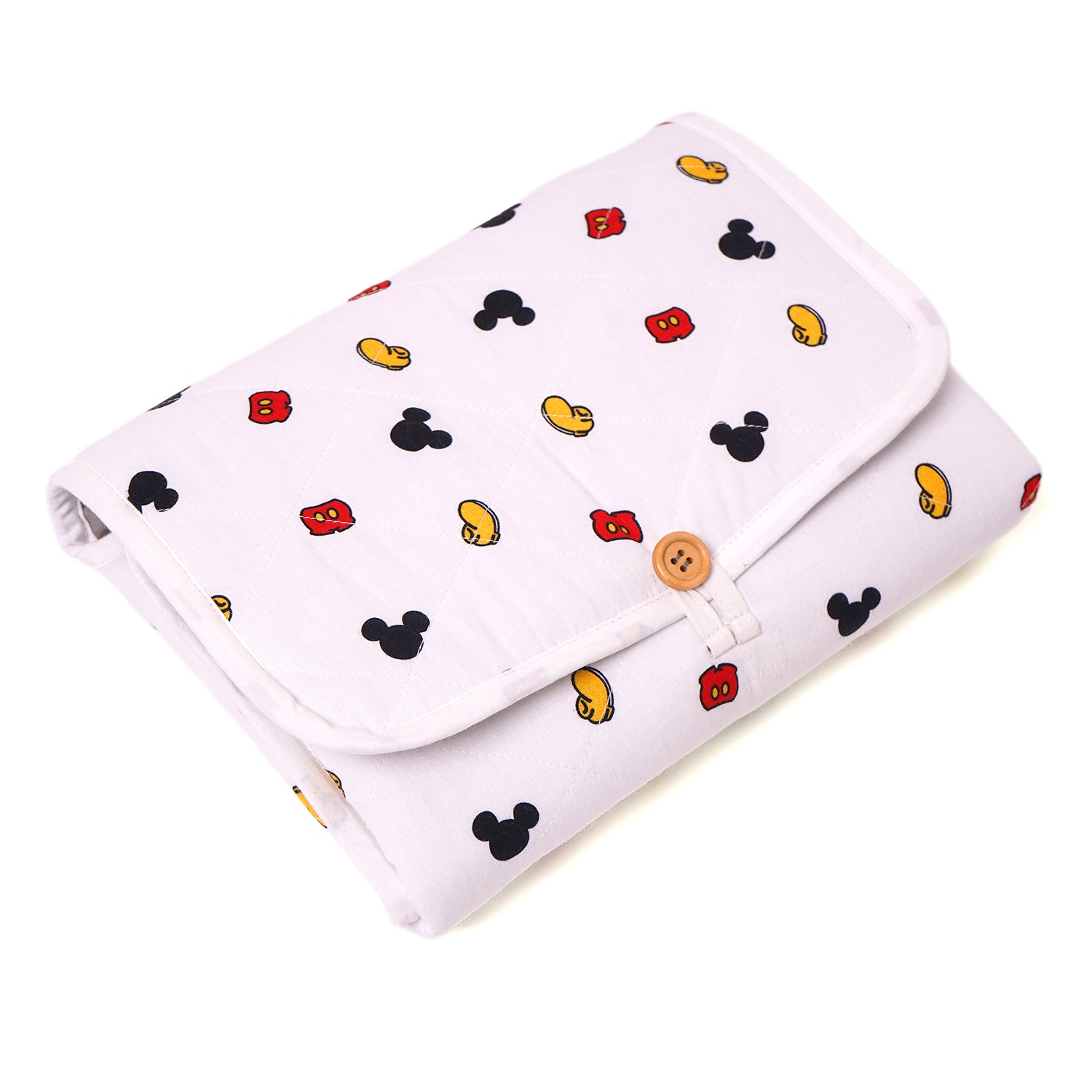 A white changing Mat with a pattern of Mickey Mouse heads and ears in red and black.