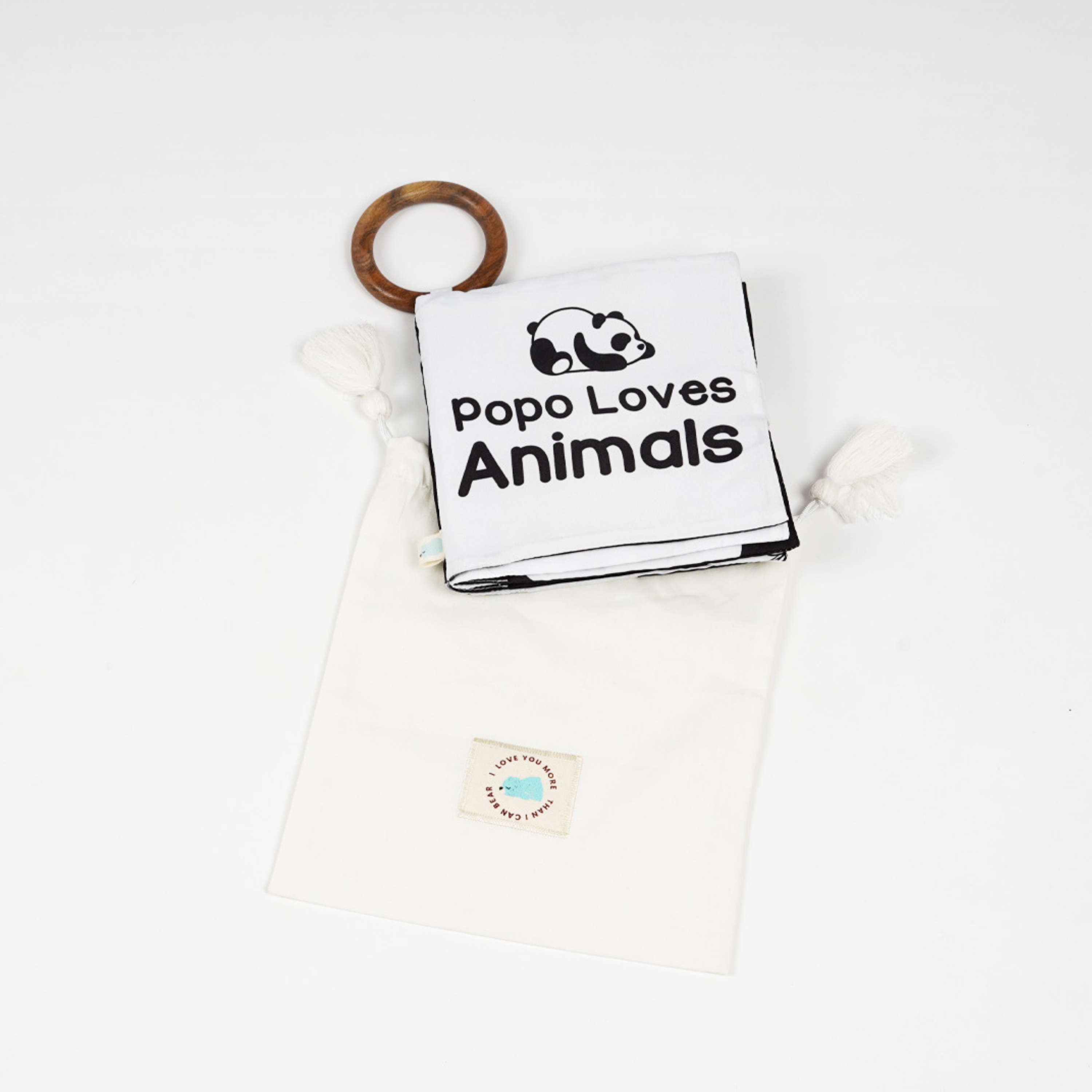 A balck and white baby cloth book 'popo loves animal' and a panda made on it, accompanied by a wooden teether for baby