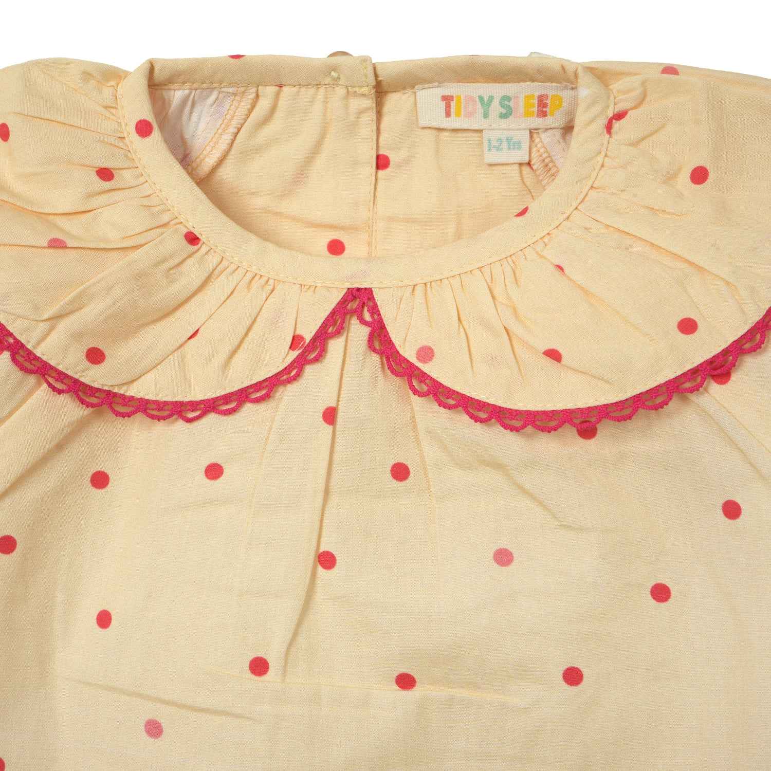 Closeup of a yellow color with red polka dots nightdress for baby girl