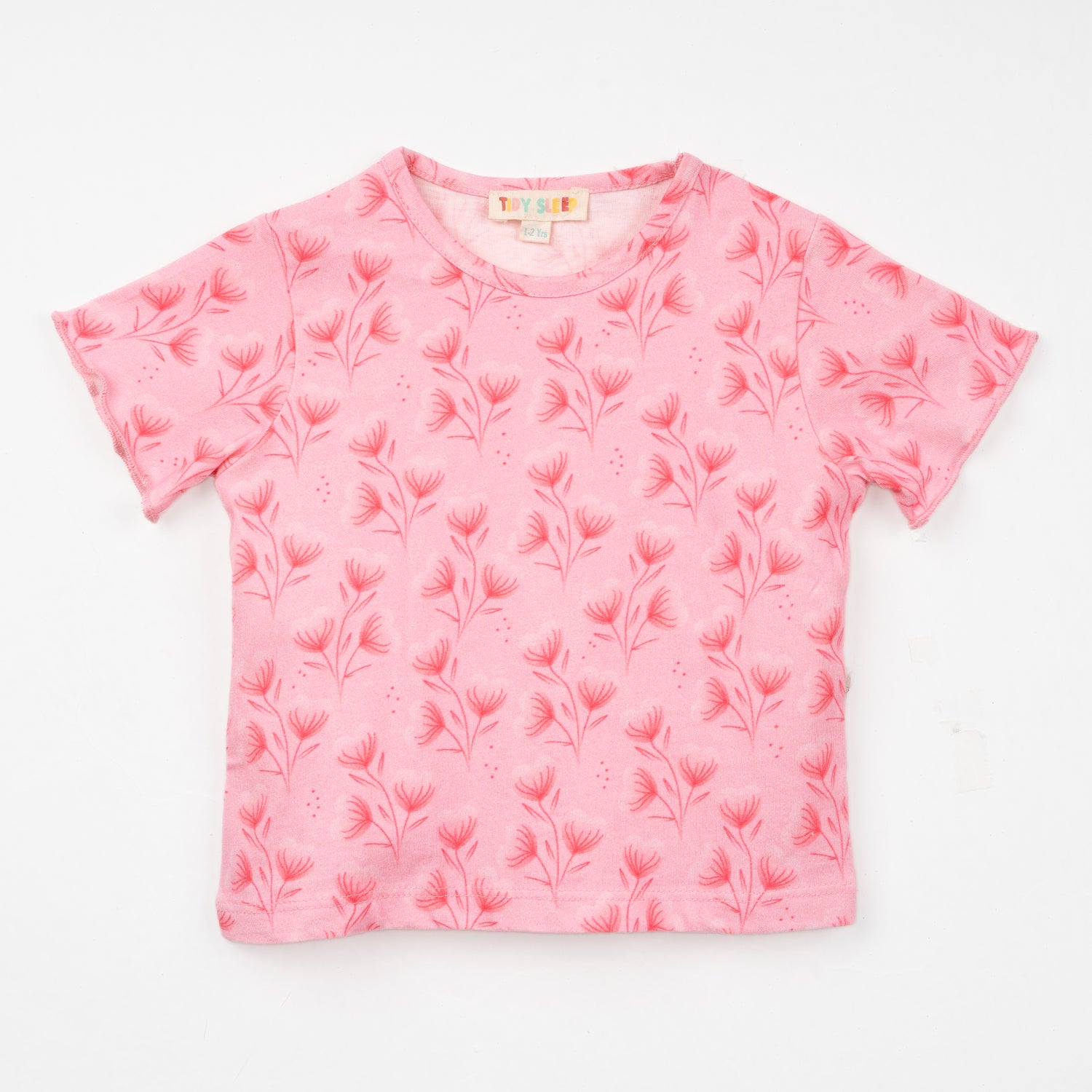 A soft pink t-shirt for baby featuring a delicate floral pattern, perfect for casual wear, displayed against a white background.