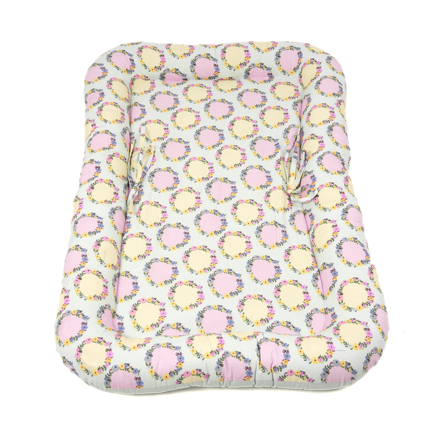 Top view of Aapadded baby gadda set featuring a floral pattern with pink and yellow accents, offering comfort for infants.
