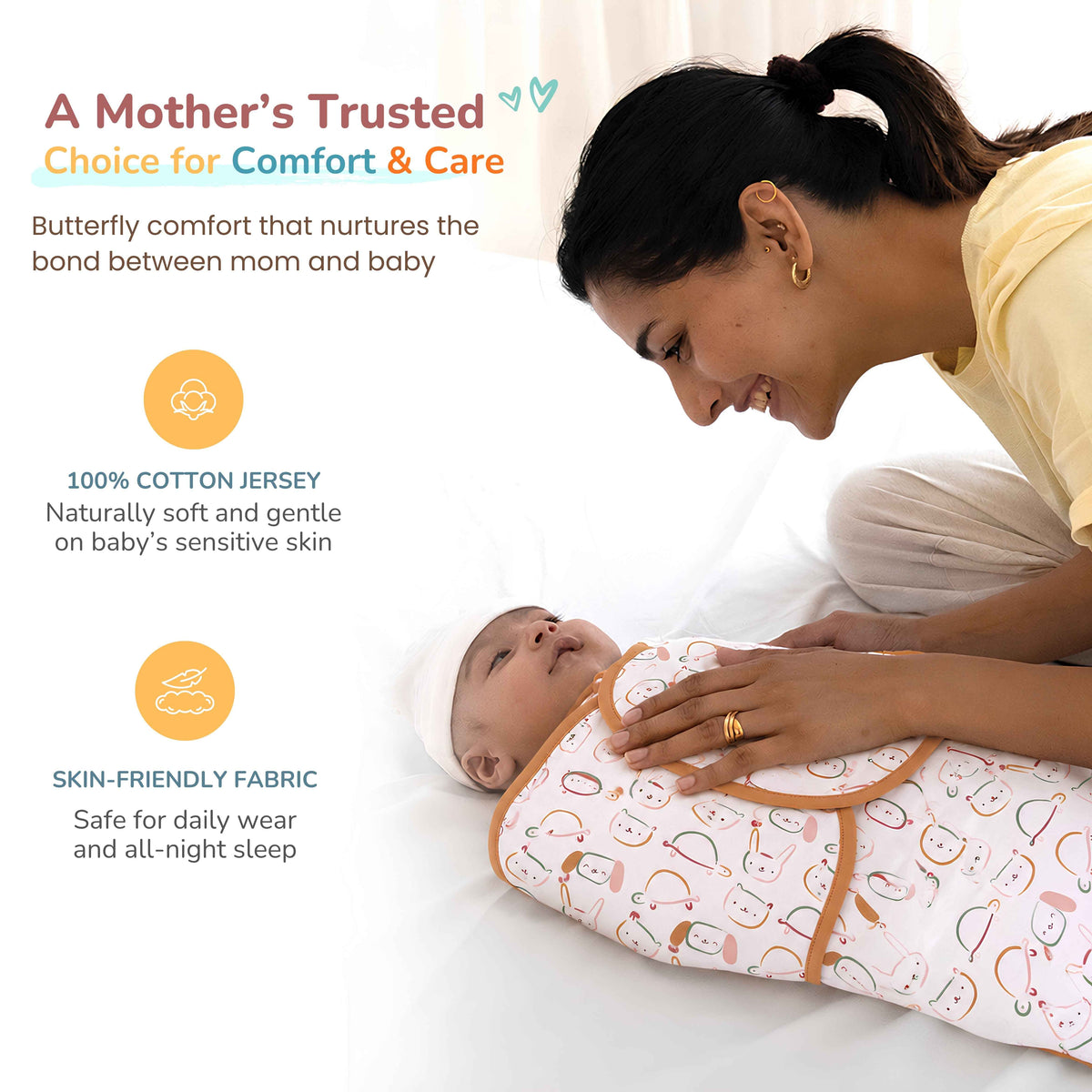 A baby swaddle wrap with a cute animal print and orange trim, shown being worn by a baby while a mother looks on lovingly. 