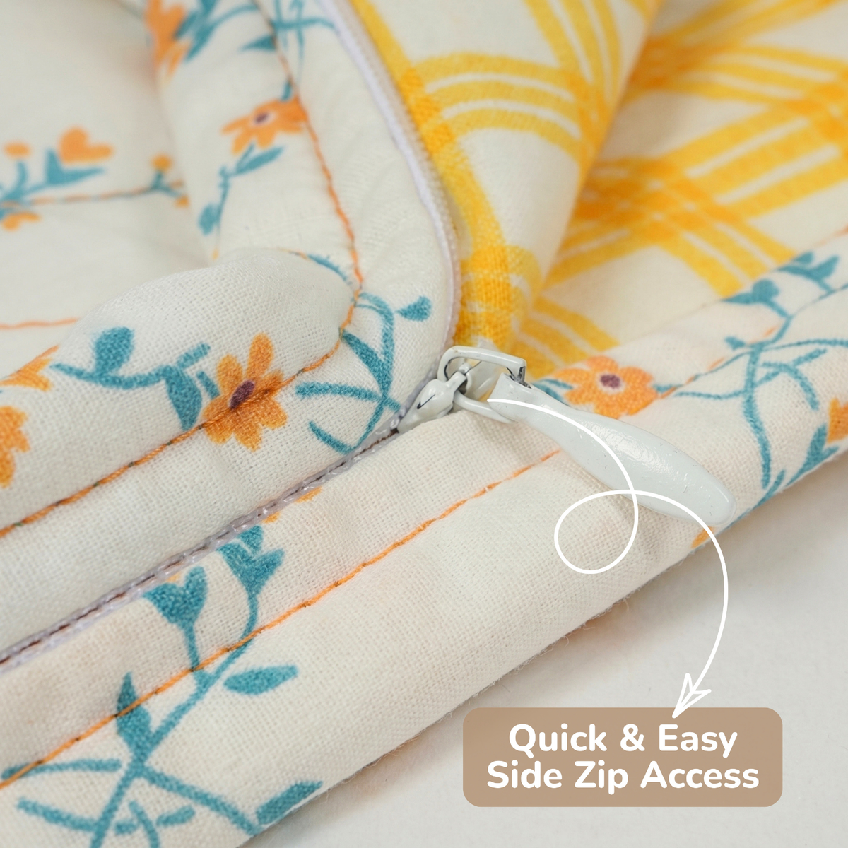 Close-up of a quilted cushion cover  of sleep slack with a floral and yellow plaid pattern, showing a white side zipper with a pull tab and an overlay text reading 'Quick & Easy Side Zip Access'.