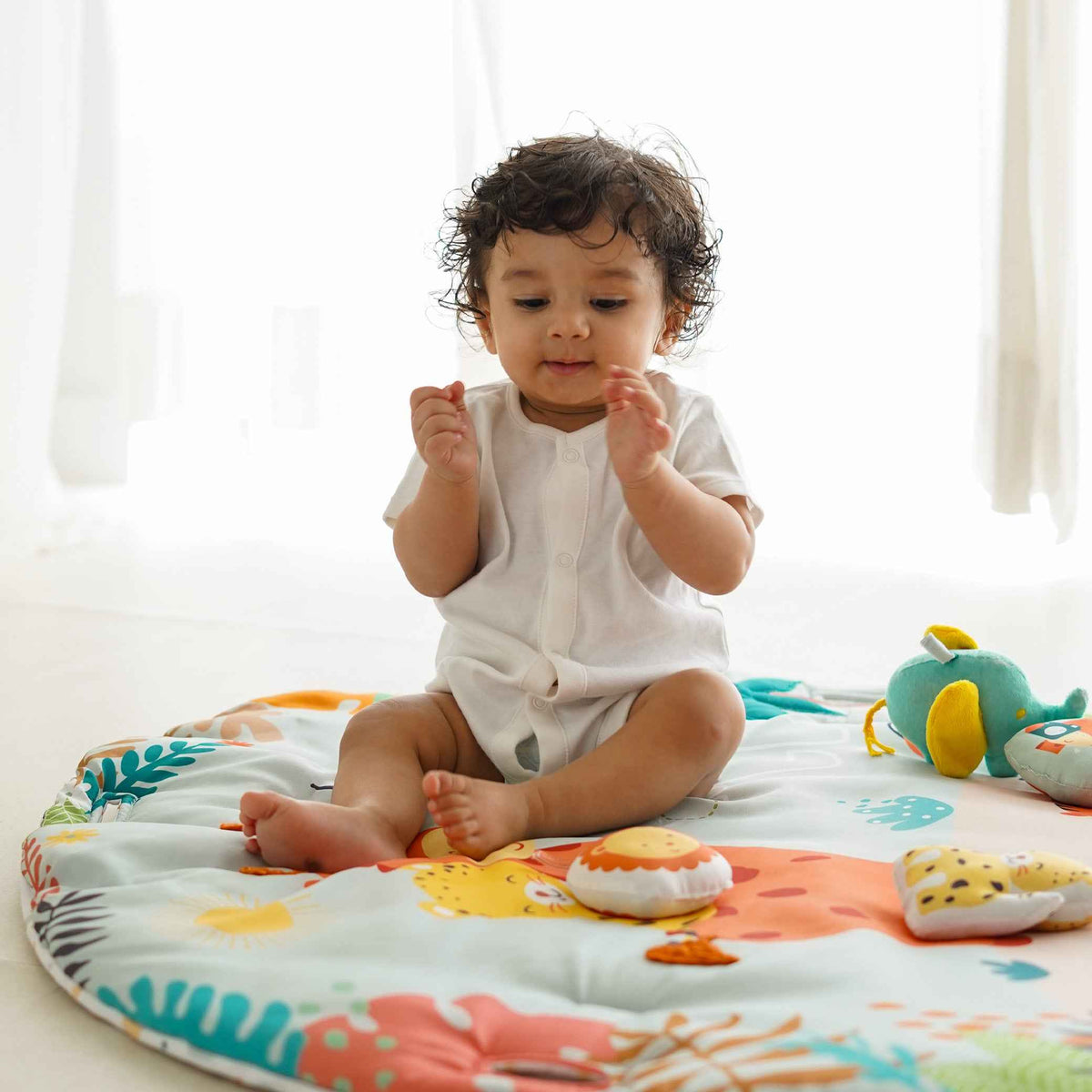 A baby sitting in a colorful play gym surrounded with toys